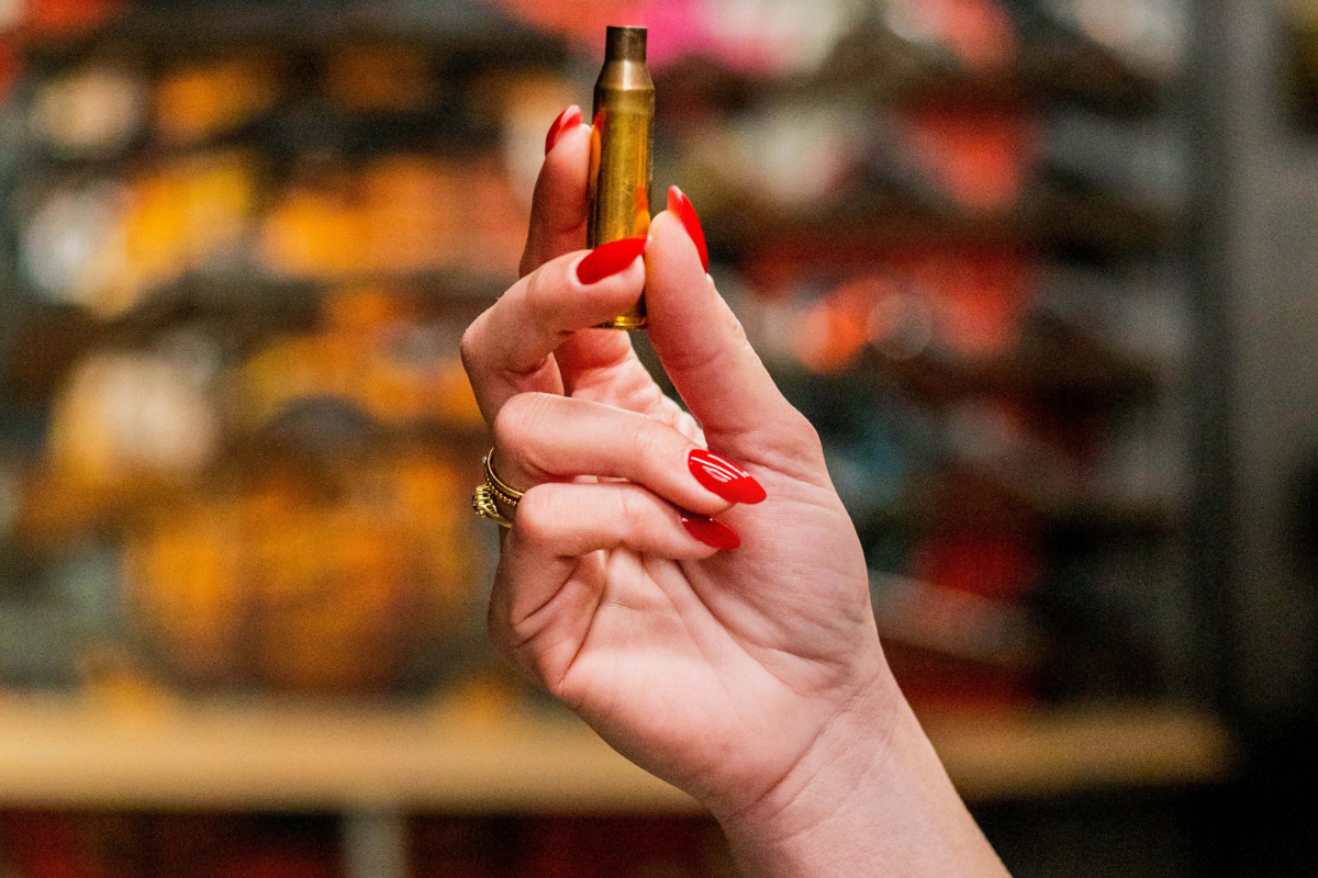 Close-up of a hand holding a spent bullet casing as a souvenir from the Krakow shooting range.