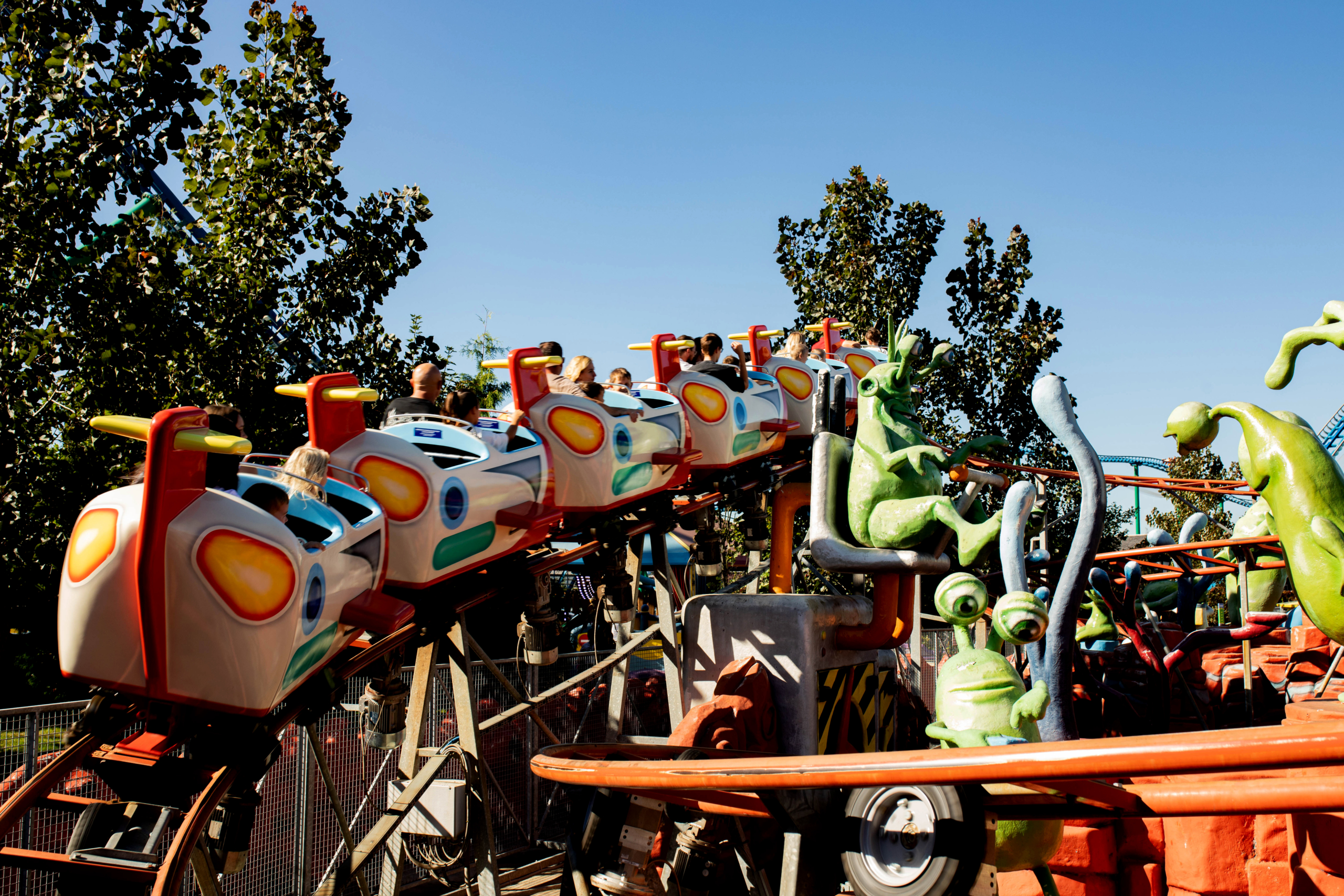 Fun ride in the family zone in Energylandia Family coaster cars in a themed area with cartoon alien figures at Energylandia (KrakowDirect day trip).