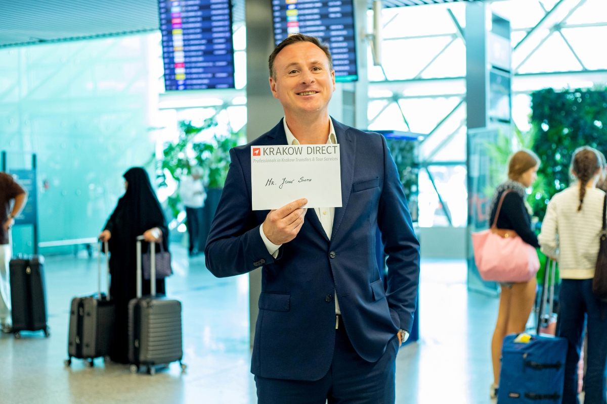 krakow-airport-pickup-sign Driver holding a name sign at arrivals in Krakow Airport
